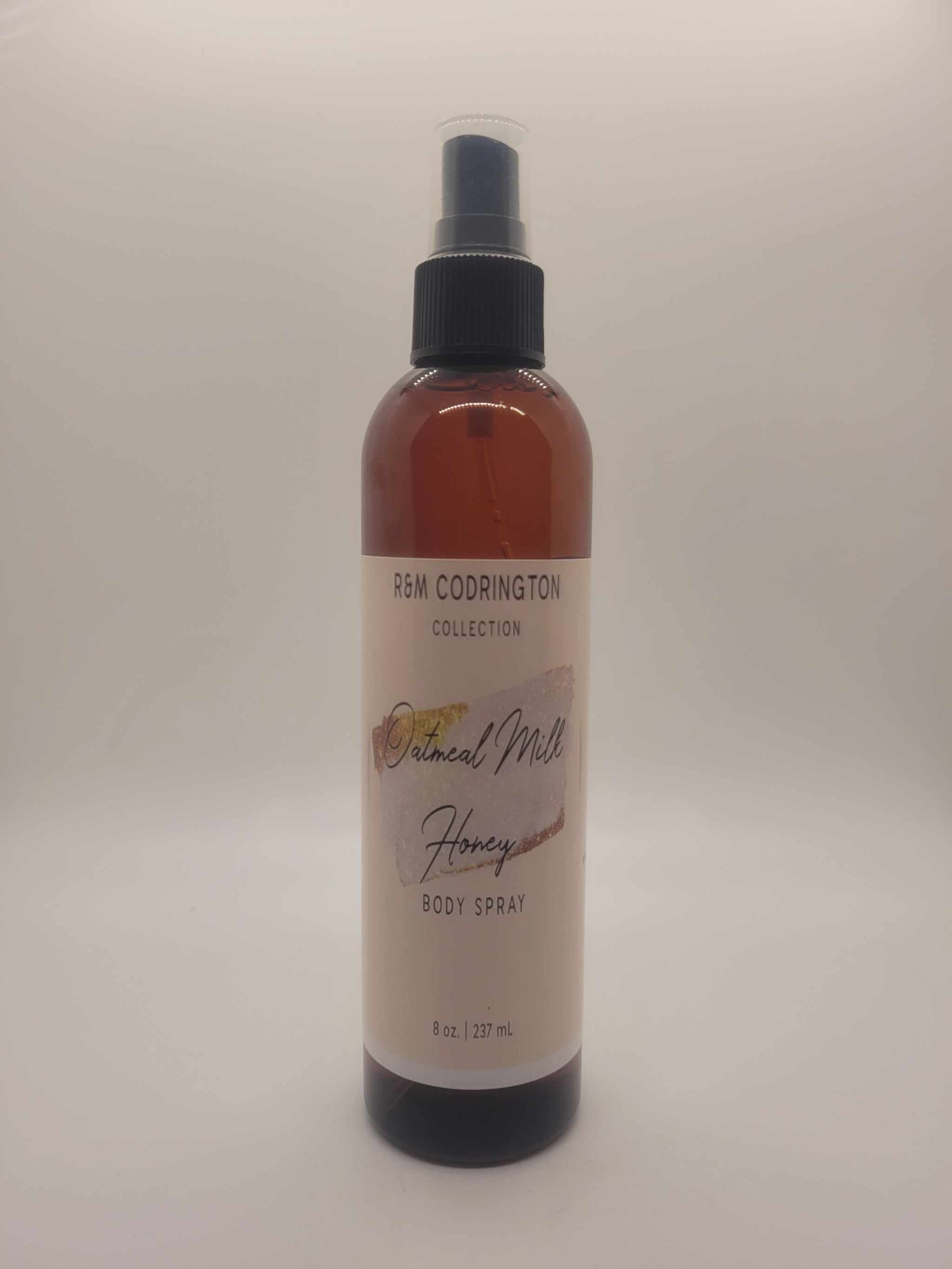 Oatmeal Milk Honey Body Spray bottle with brown liquid and black spray cap