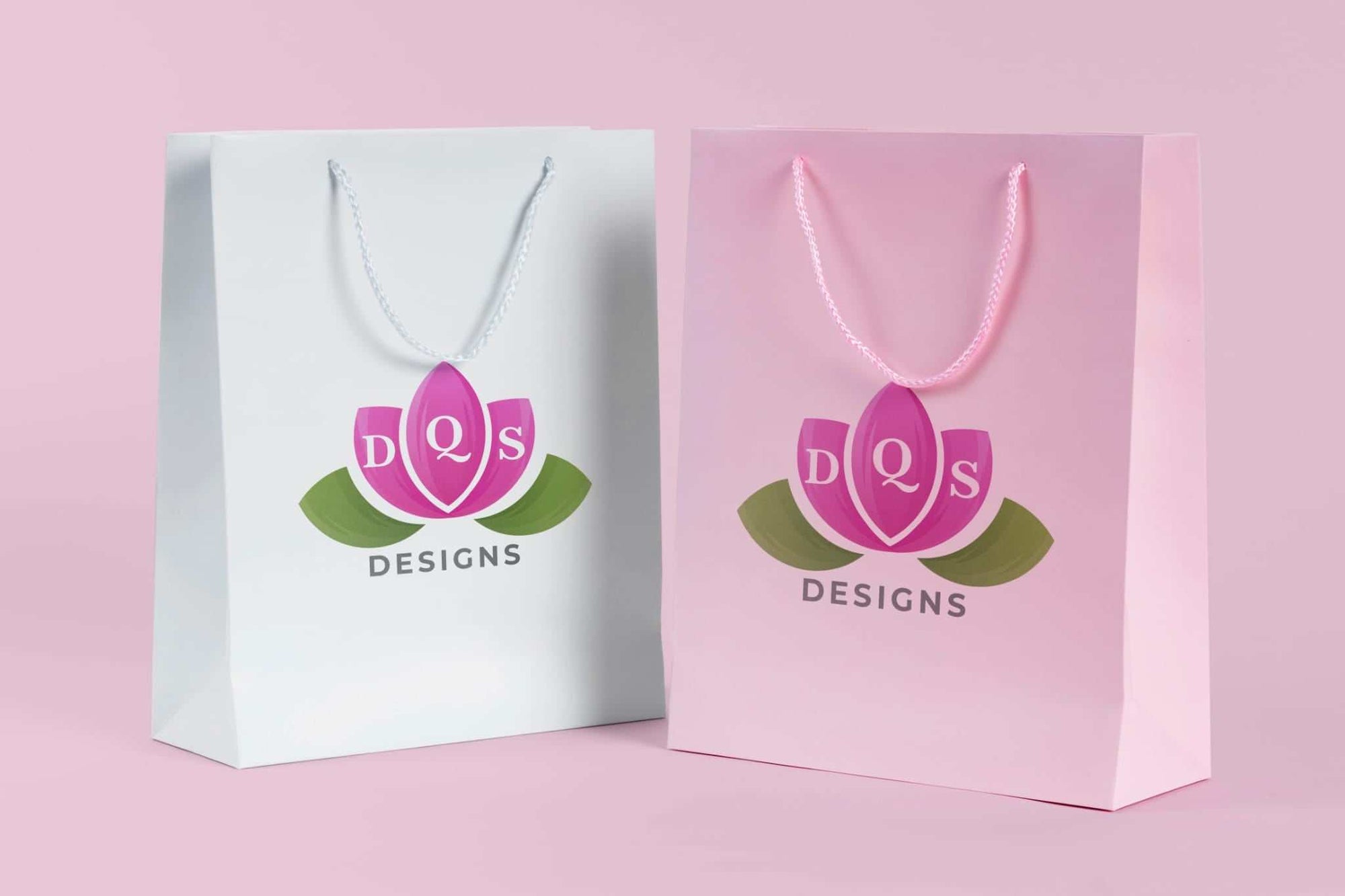 Divine Quality Services LLC gift bags with pink and white floral logo on pastel background