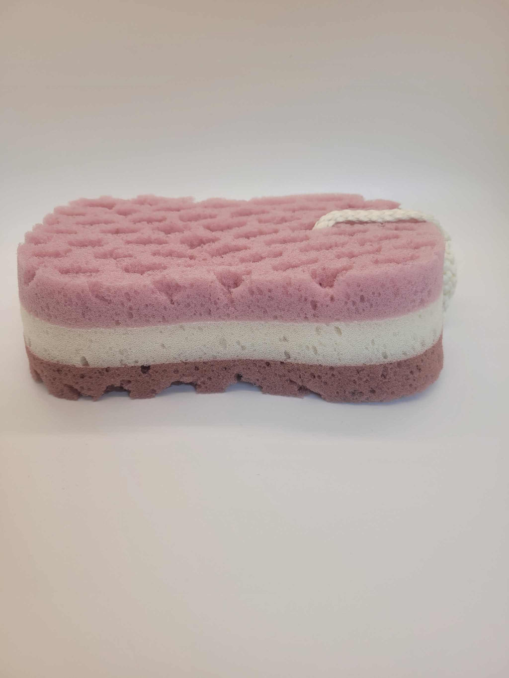 Multi-layered pink and white bath sponge with textured surface and hanging rope for shower use