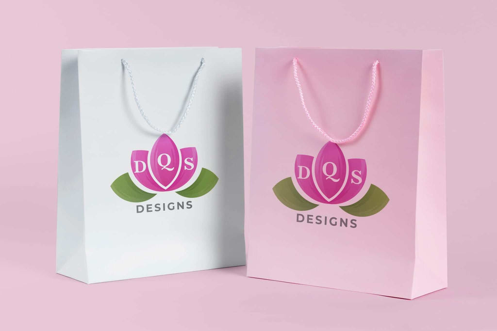 Divine Quality Services LLC gift bags with pink and white floral logo on pastel background